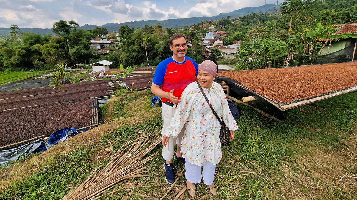 Ray and Yana standing in the next to drying coffee beans in Indonesia